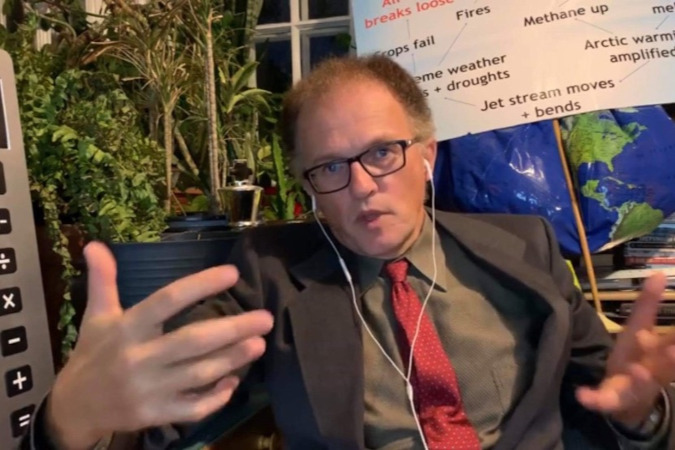 Paul dressed in a suit sitting and explain something
