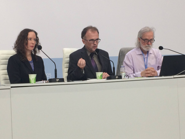 Regina, Paul and Peter sitting in Press conference room during a presentation